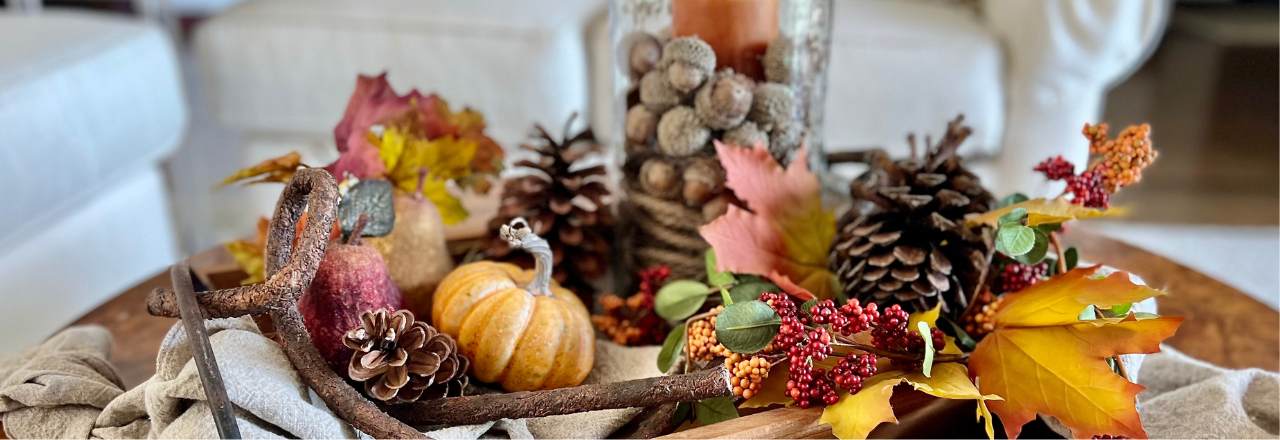 traditional Fall arrangement on a wood tray with candle in hurricane