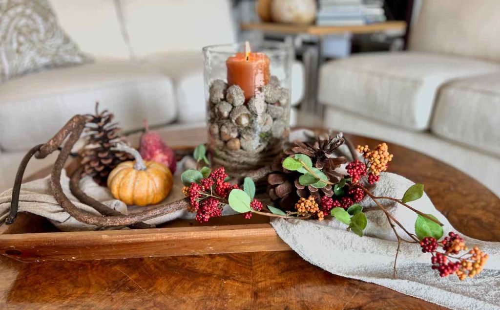 Fall Tray Arrangement With a candle hurricane, pumpkin and acorns