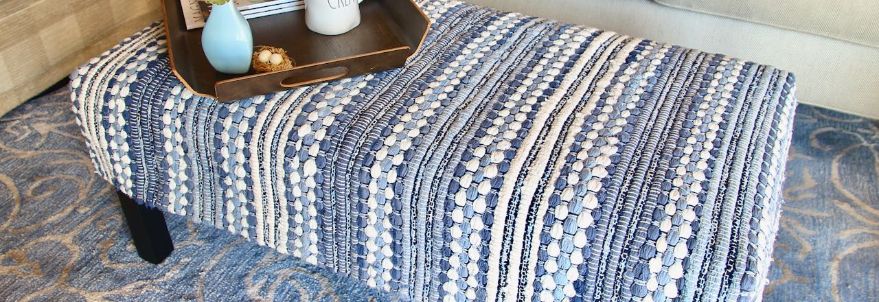 wide closeup of blue and white rag rug made into an ottoman slipcover