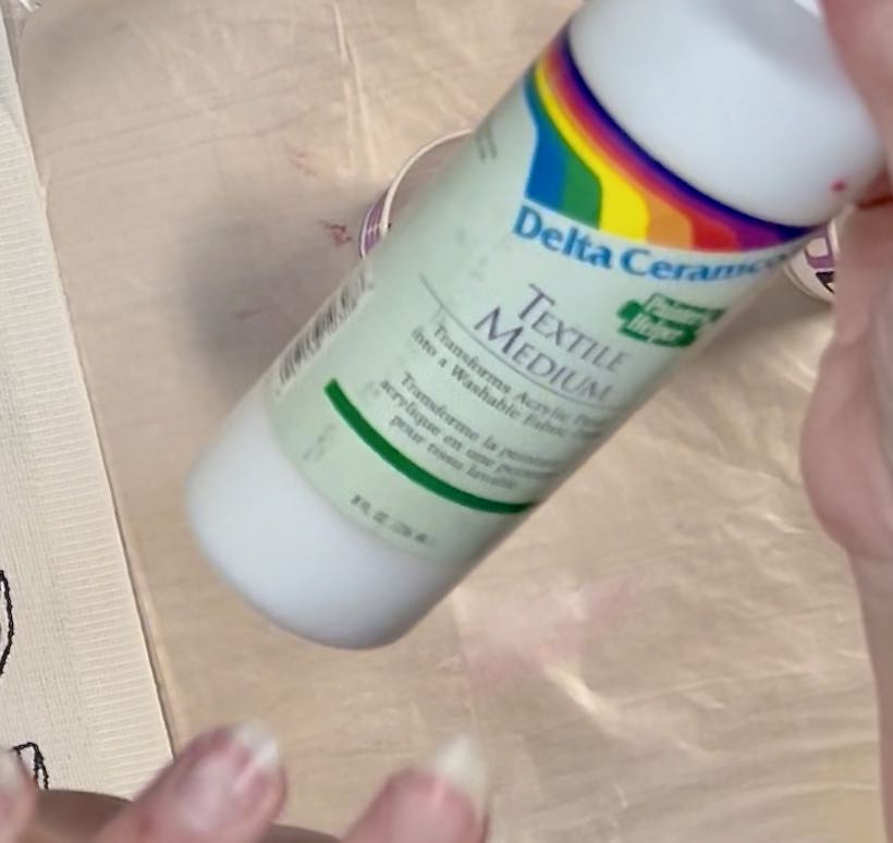 bottle of textile medium in a woman's hands