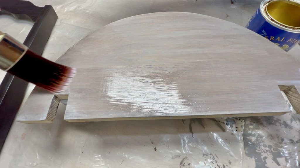 Applying top coat with a large round Dixie Belle brush