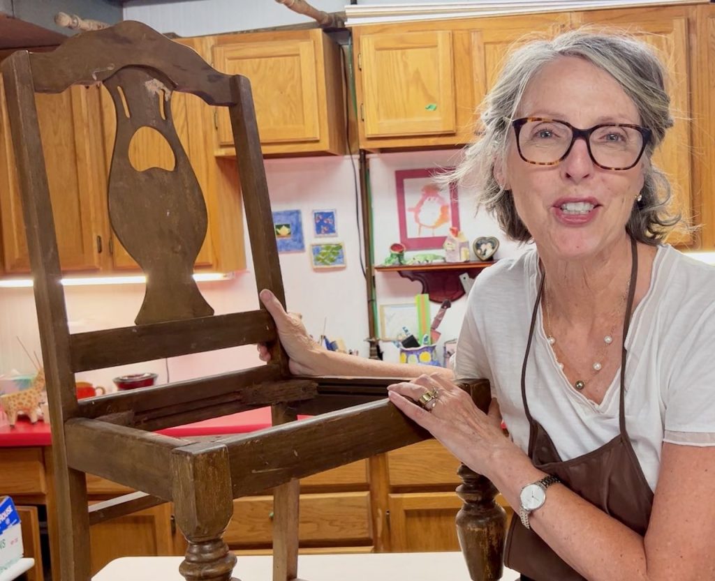 Woman sitting next to a badly worn vintage dining chair