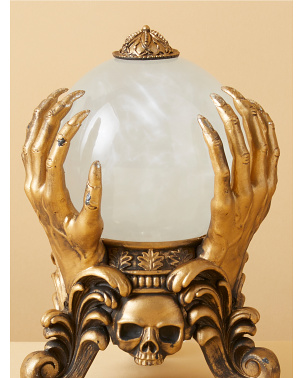 lighted globe held up by creepy gold hands