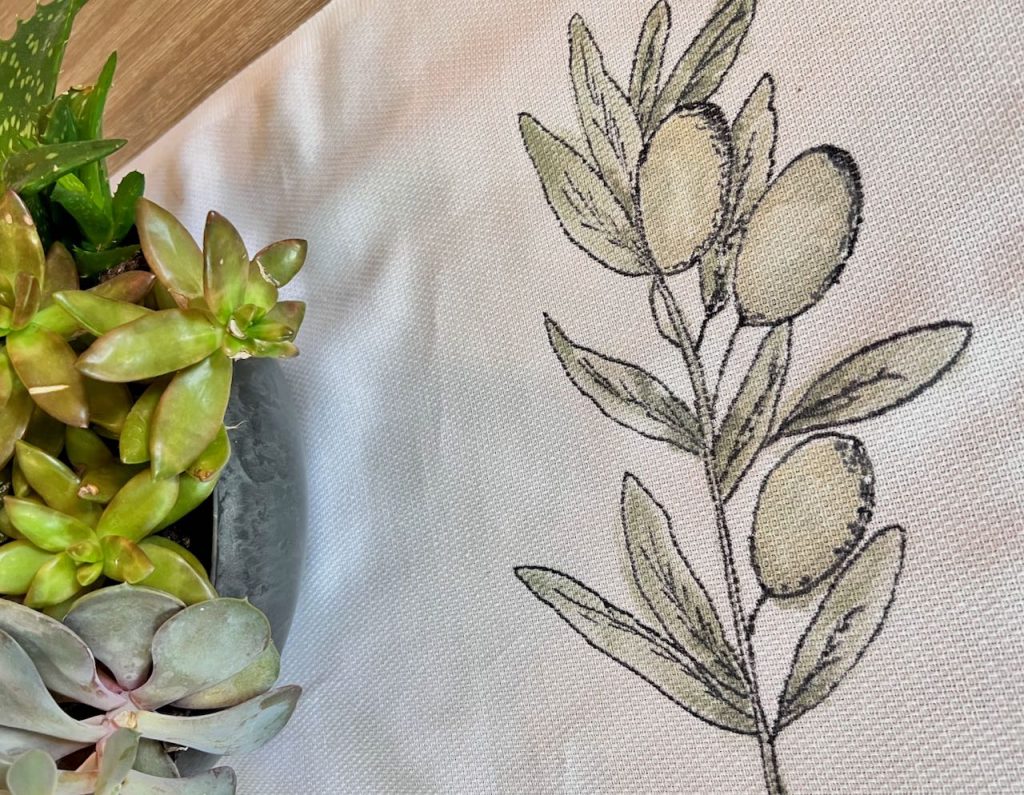 closeup of an olive branch painted on a table runner