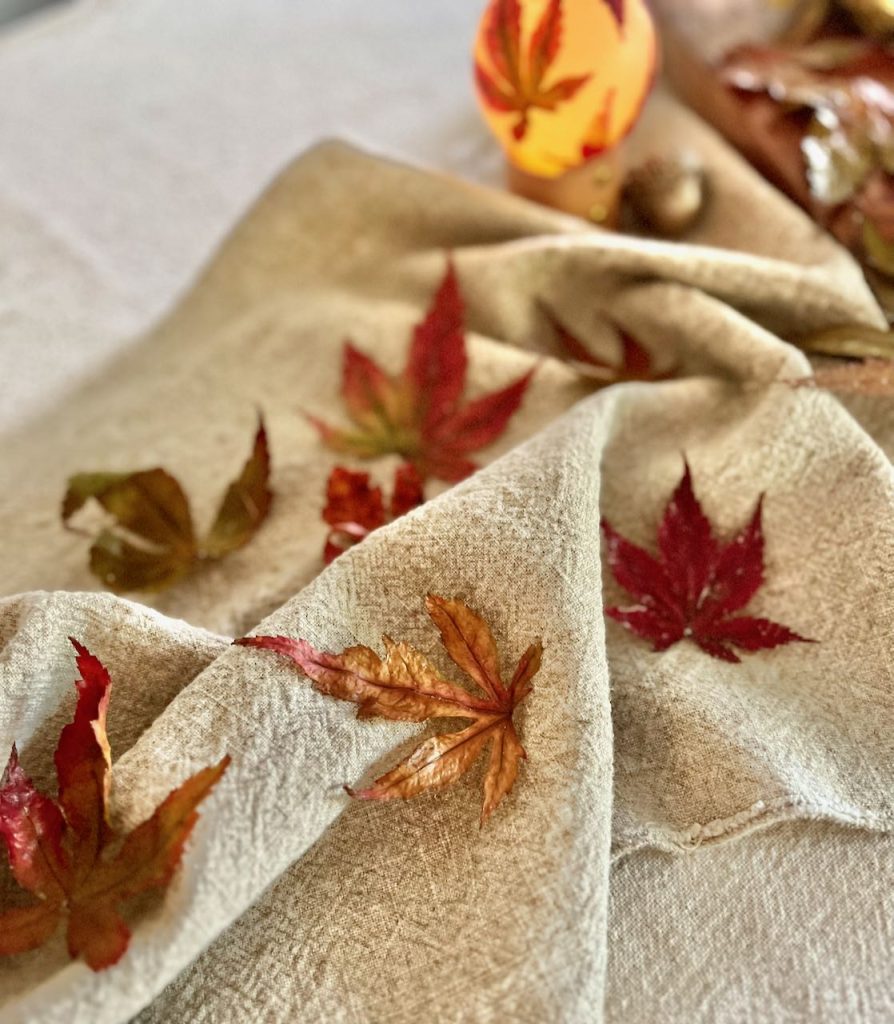 closeup of preserved leaves on a linen table runner