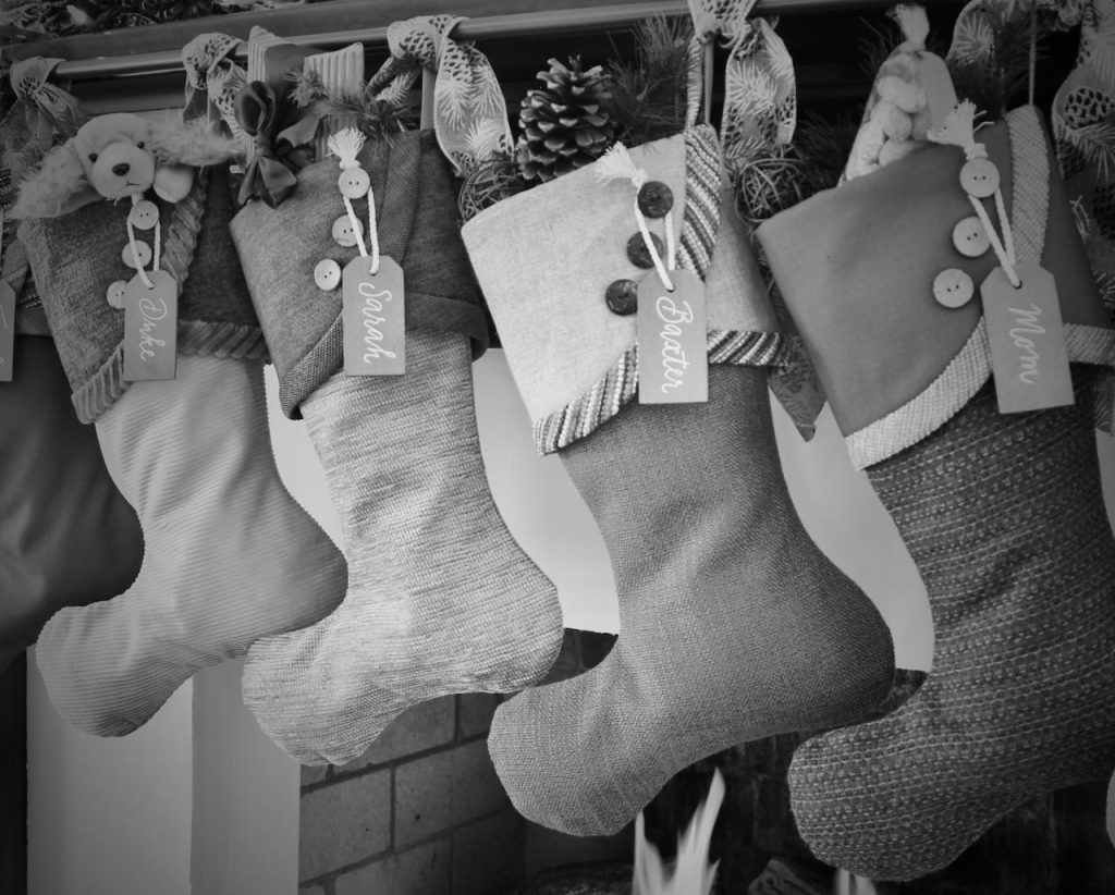 four stockings hanging from a mntel, but shown in black and white