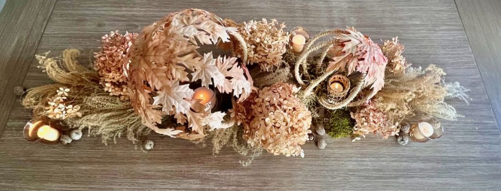 overhead view of a Fall centerpiece of two rope and leaves globe suprrounded by dried grass and dried hydrangea