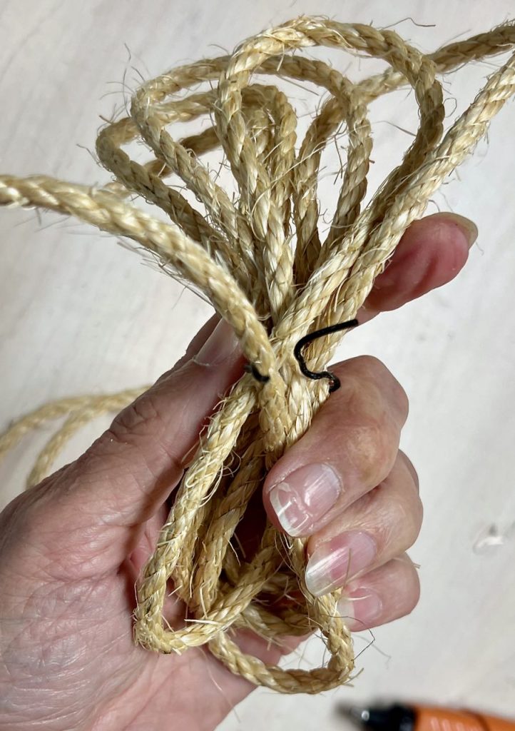 woman's hand holding bundle of rope with a twist tie about the tie it up