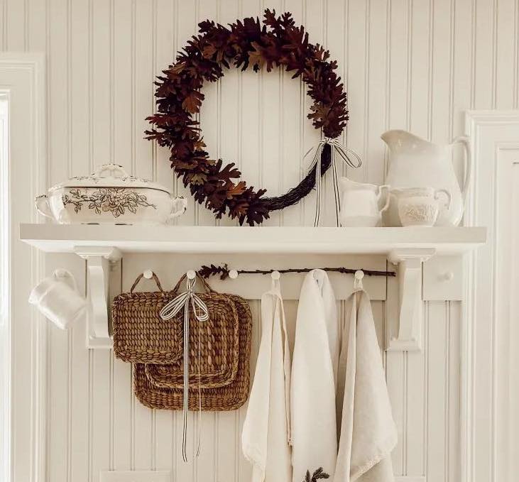 Simple Fall wreath hanging over open kitchen shelves
