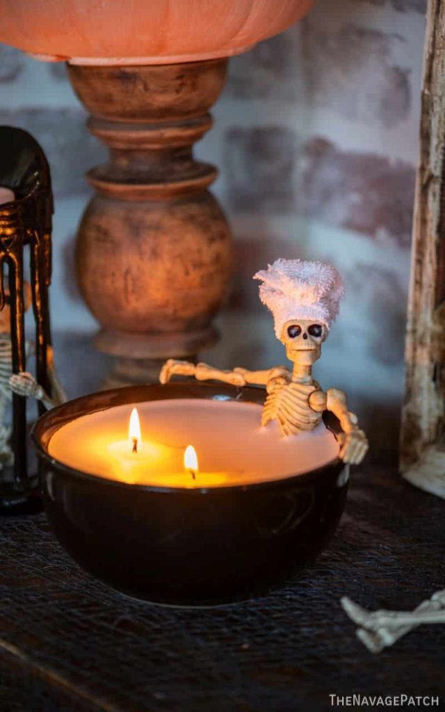 Skeleton body extending out of a tub of white wax looking like a skeleton at the spa candle