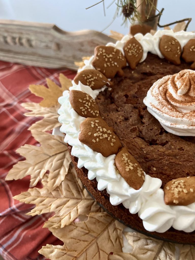 closeup of eggnog custard pie on a ring of leaves on a cake plate