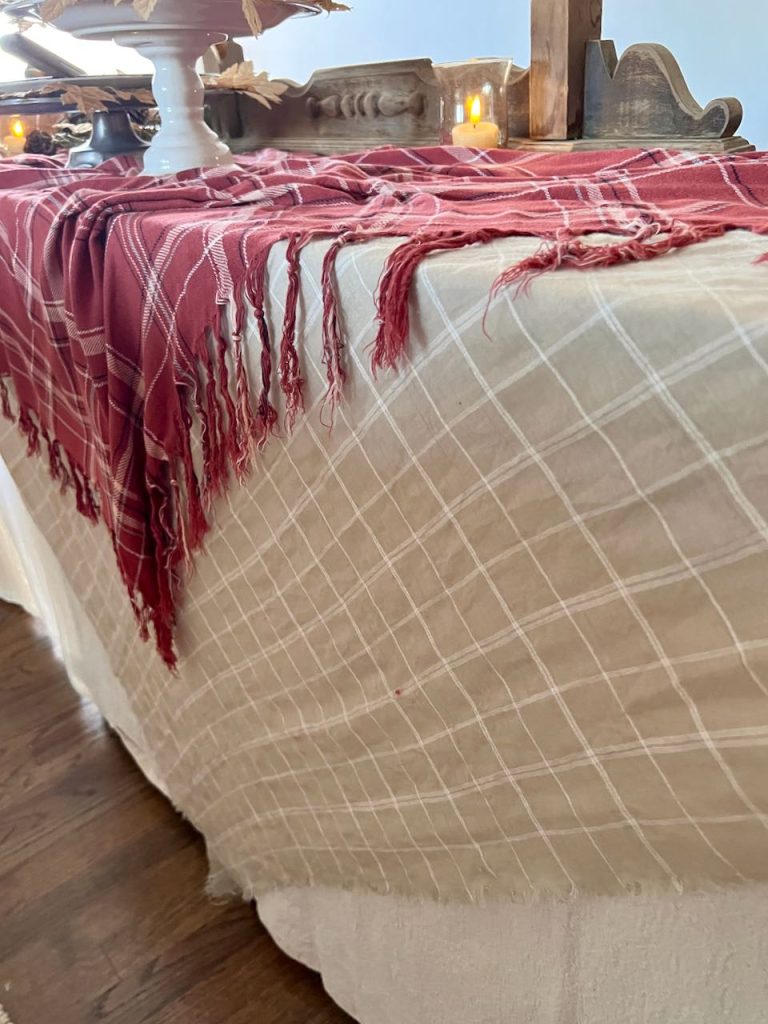 two plaid tablecloths shown layered over a large cloth to the floor