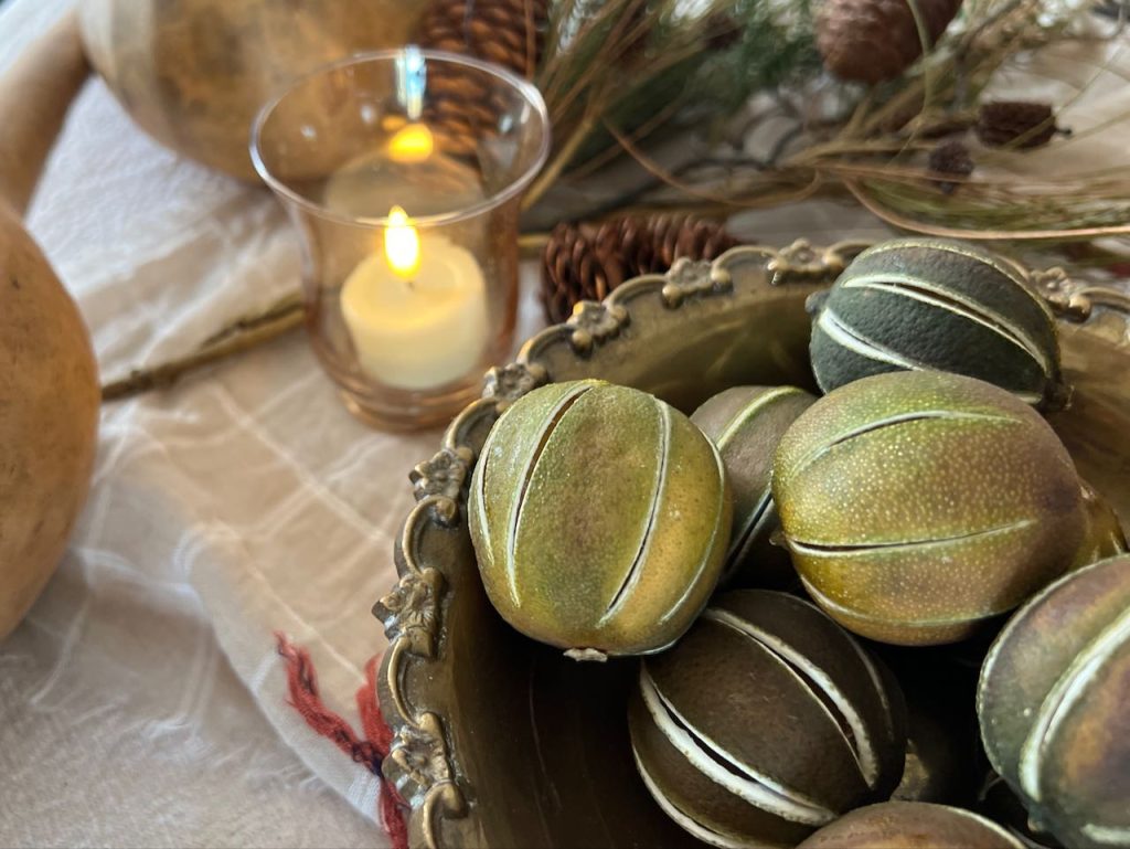 closeup of a bowl of dried limes beside a votive candle