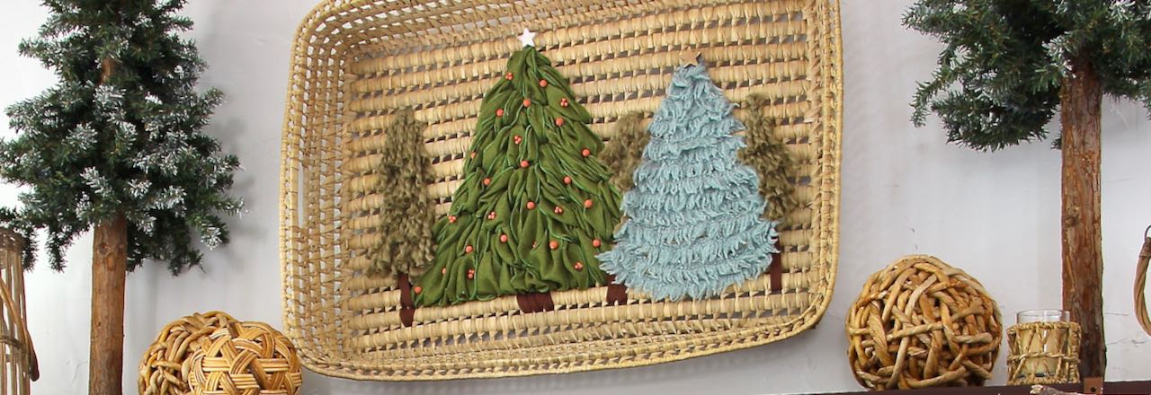 Christmas tree in a forest is embroidered with ribbon and yarn to the inside of a large basket tray