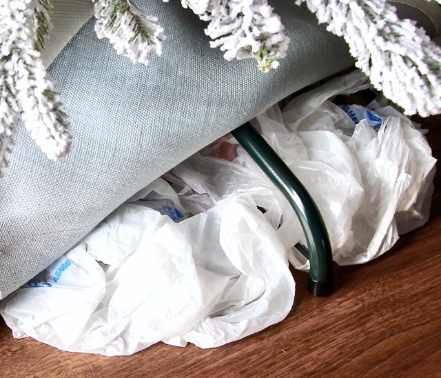 closeup of wadded up plastic bags stuffed under a tree skirt