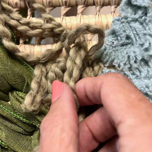two ends of yarn being pulled through a loop