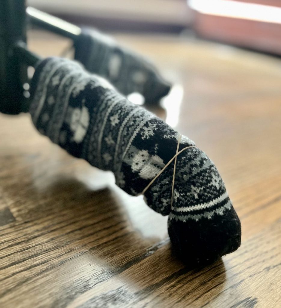 closeup of thick socks on the feet of a tree stand held on with rubber bands