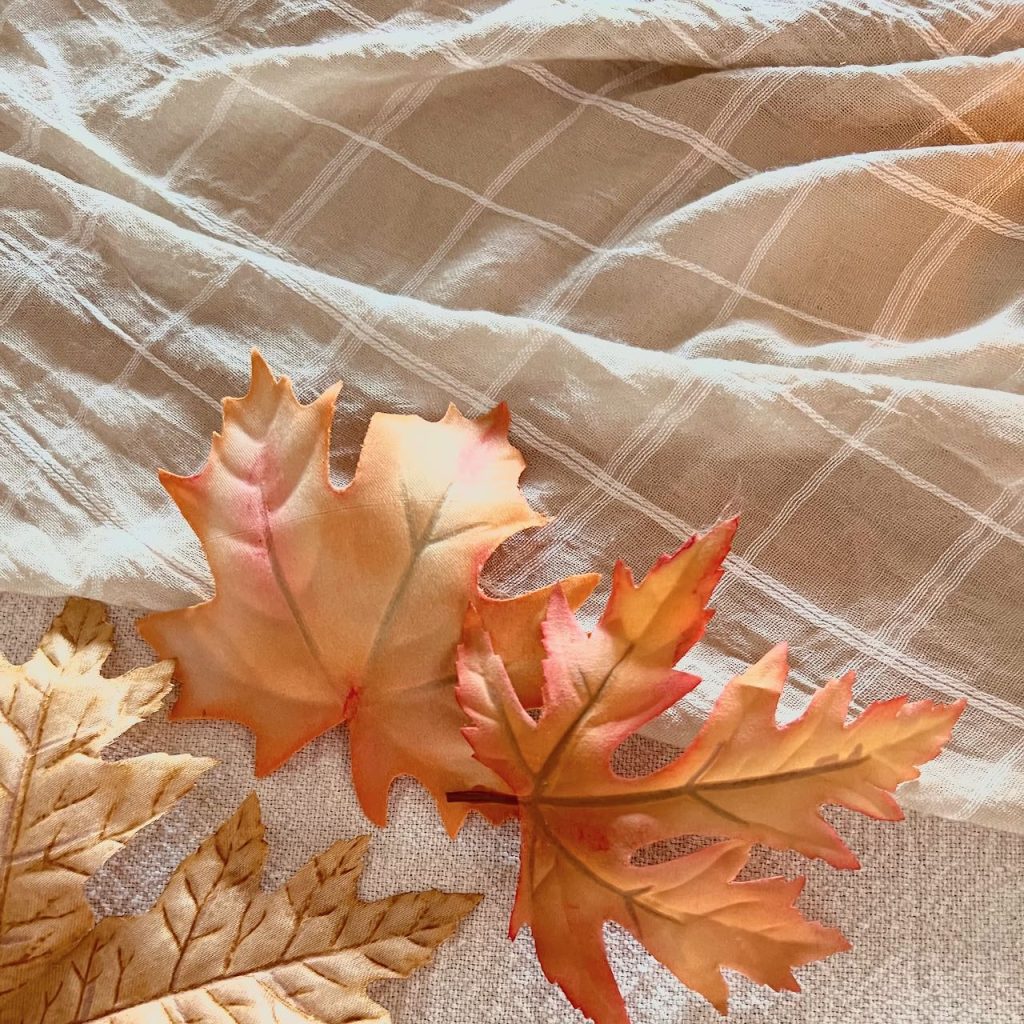 closeup of faux leaves next to the shawl table runner