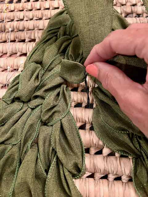 twist tie is around the end of the ribbon and is threading it back through the basket weave