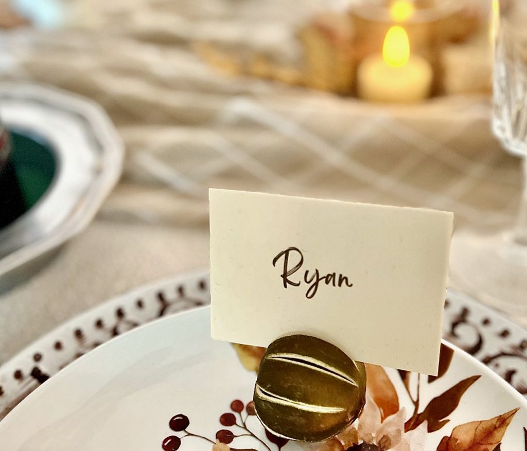 closeup of a dried slitted lime holding a place card on a floral plate