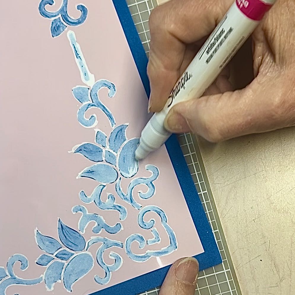 woman using sharpie oil-based marker to add additional highlights with the stencil still in place