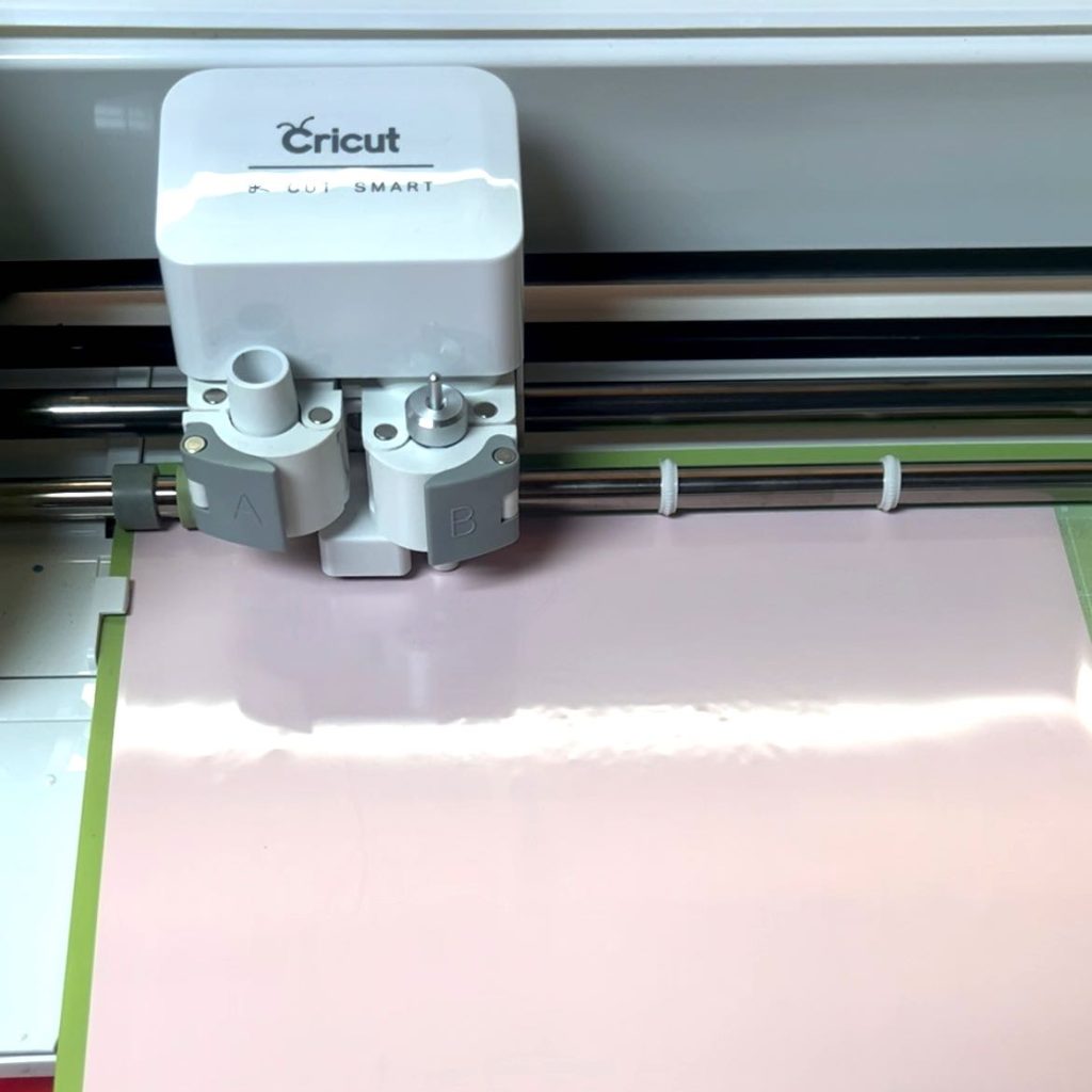 closeup of cricut machine cutting the vinyl stencil material