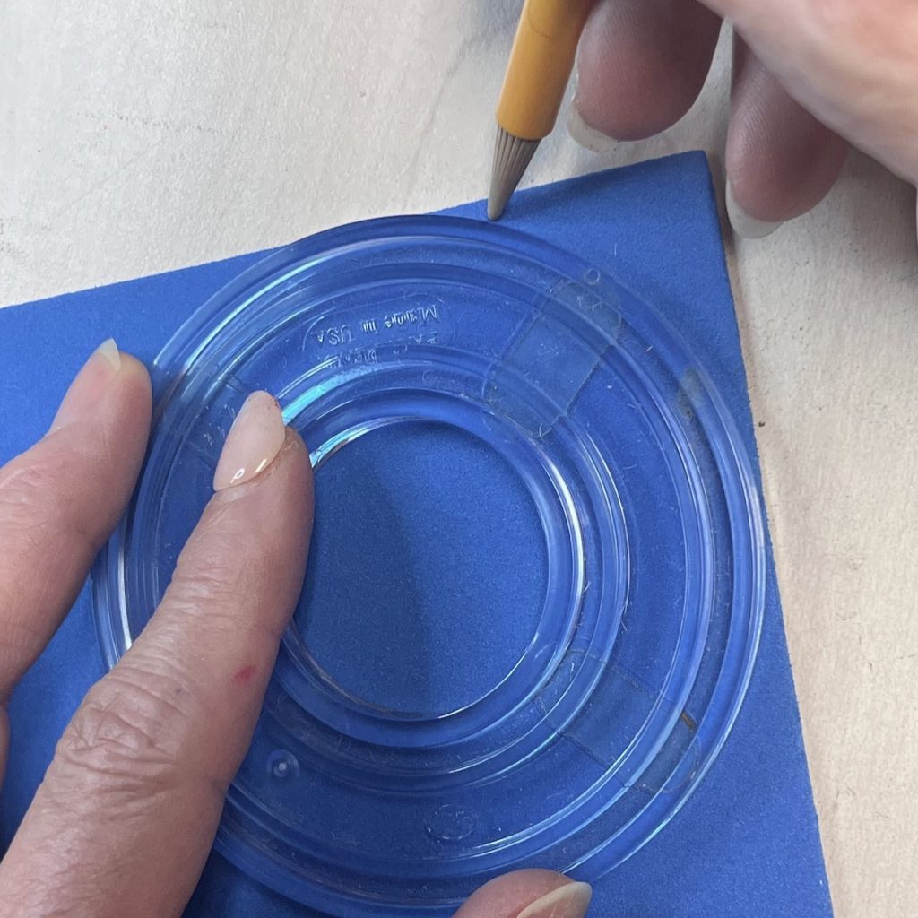 woman's hands using a circular guide and pencil to mark the rounded corner