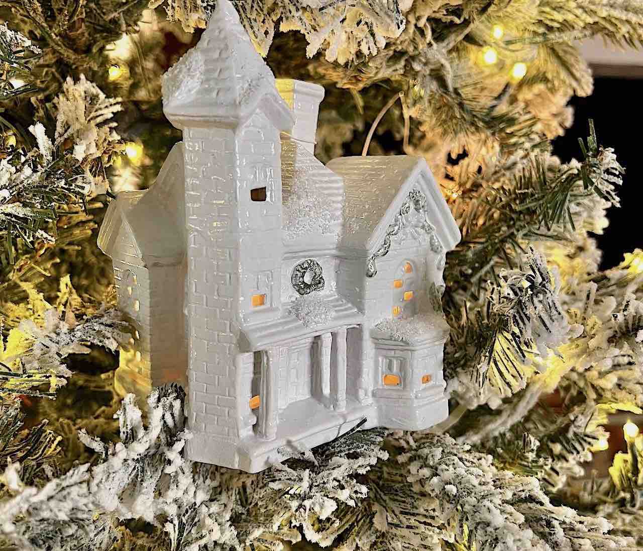 closeup of a ceramic Christmas house painted glossy white in a Christmas tree