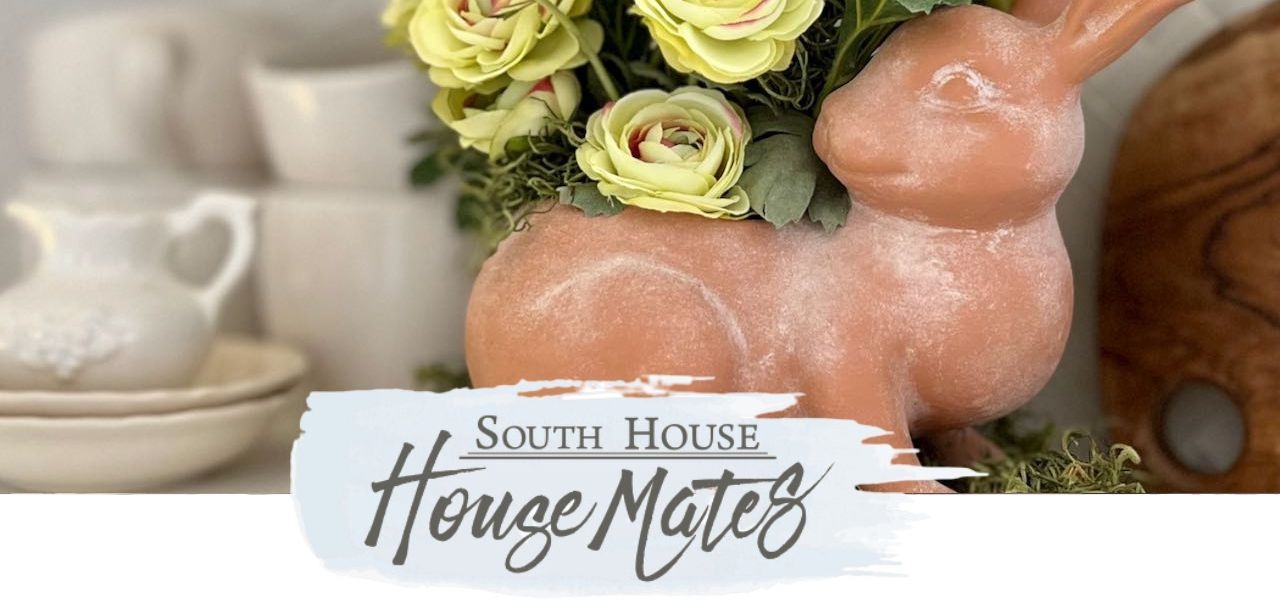 House Mates Newsletter logo over a closeup of a terracotta bunny planter filled with ranunculus