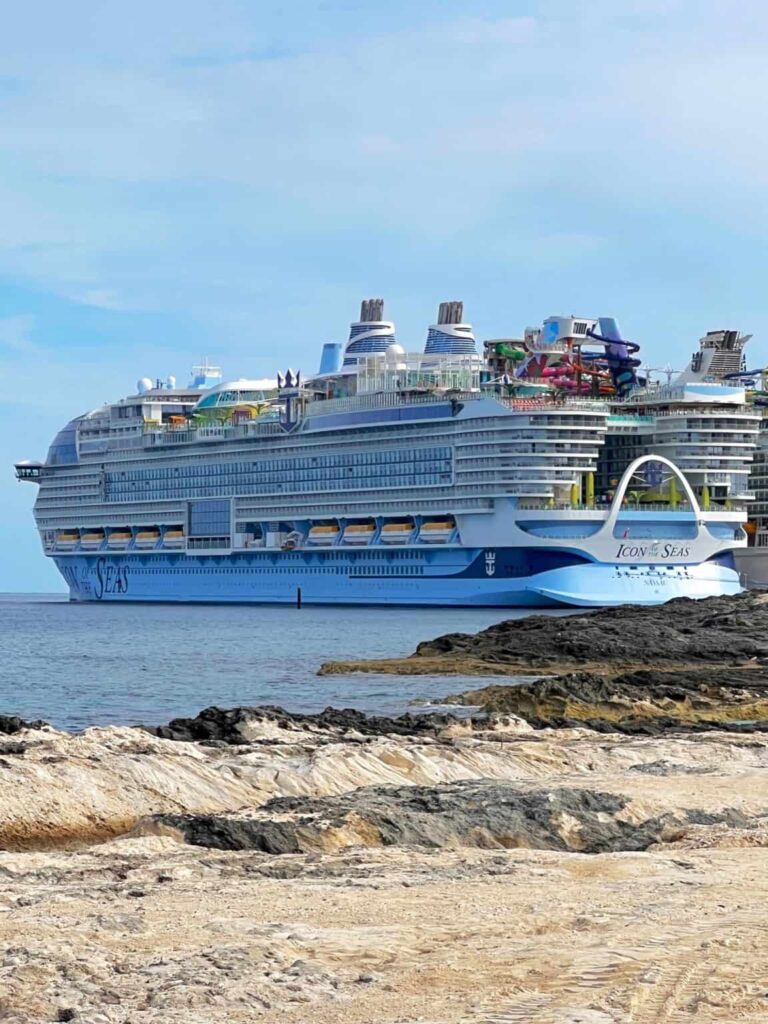 Large cruise ship next to a sandy beach