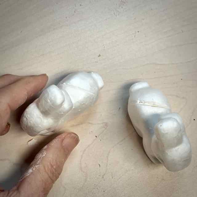 woman's fingertips are aligning the slits in the back of two bunnies