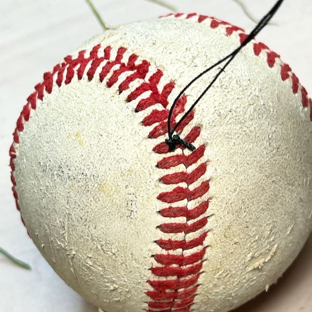 knot around baseball lacing is shown secure