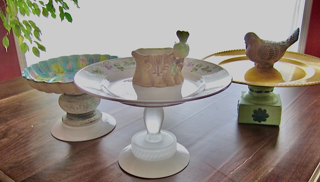 three birdbath structures are made of various stacked mis-matched thirties items