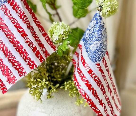 closeup of two flags in a pot of greenery
