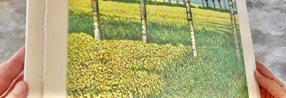 Hands hold a landscape painting featuring a row of trees against a vibrant field with yellow flowers. A vertical white line appears to the left of the image, possibly part of the painting's frame or border.