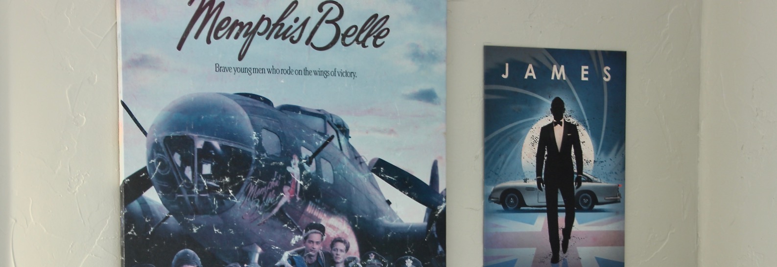Two vintage poster artworks: one for "Memphis Belle," showcasing a WWII bomber and airmen, and another featuring a silhouette of a man in a suit labeled "James," set against a car and blue background.