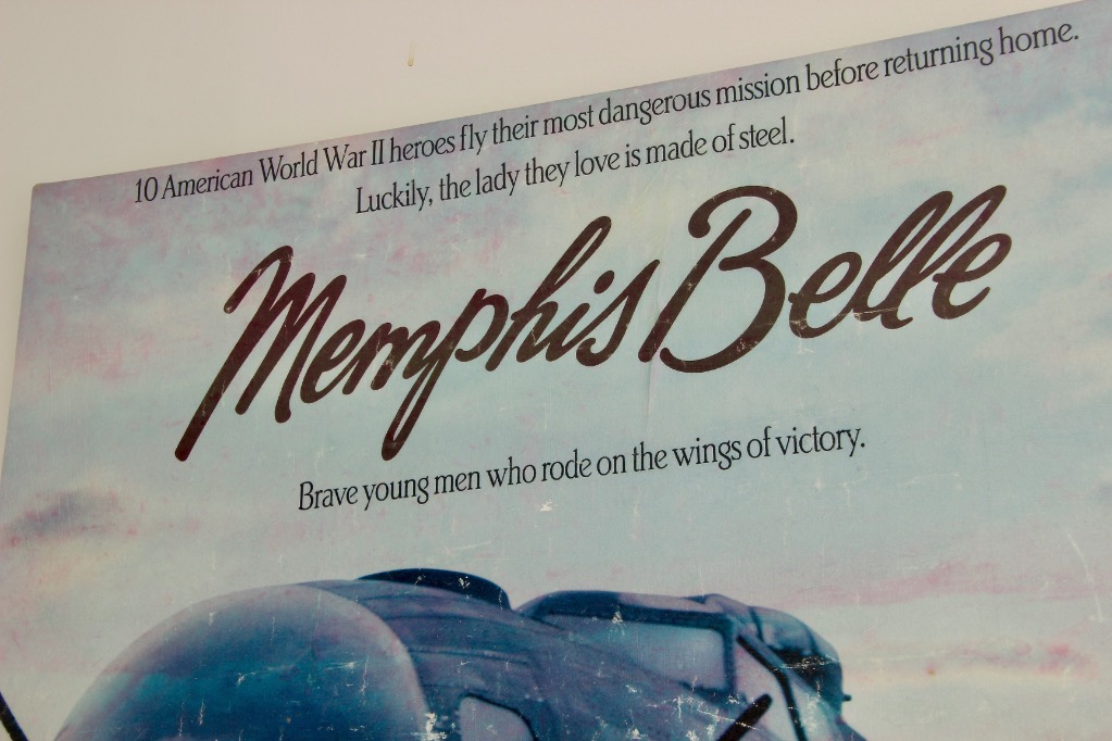 Poster featuring vintage poster artwork: “10 American World War II heroes fly their most dangerous mission before returning home. Luckily, the lady they love is made of steel. Memphis Belle. Brave young men who rode on the wings of victory.”.