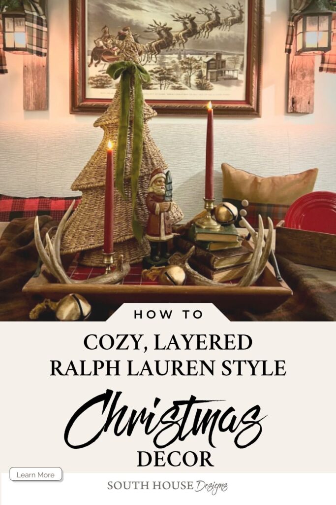A cozy Christmas display features a rustic table arrangement with a tree-shaped ornament, vintage Santa, books, antlers, and gold accents. Warm lighting and plaid details offer timeless Ralph Lauren Christmas ideas for elevated holiday decor.