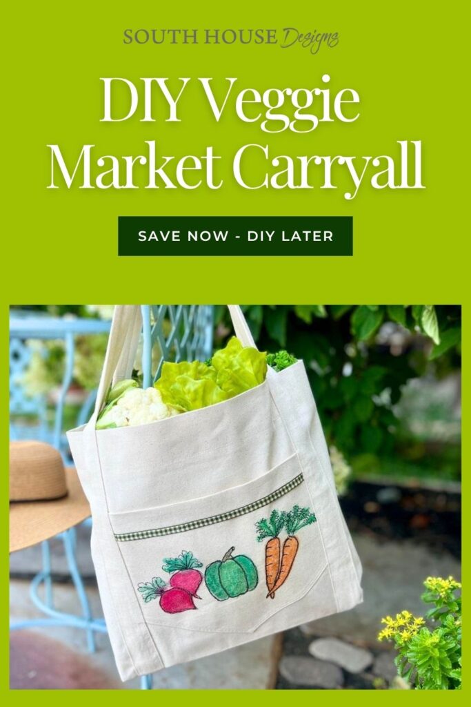 A white tote bag with colorful embroidered vegetables, filled with lettuce, hangs outdoors with greenery and a hat in the background. Text reads: “DIY Veggie Market Carryall. Save Now – DIY Later.”.