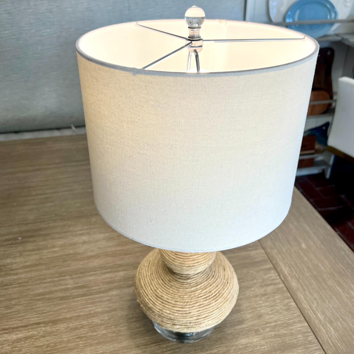 Table lamp with a drum shade and a rope wrapped base in a natural color.